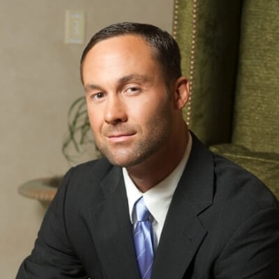 A man in black suit with blue necktie.